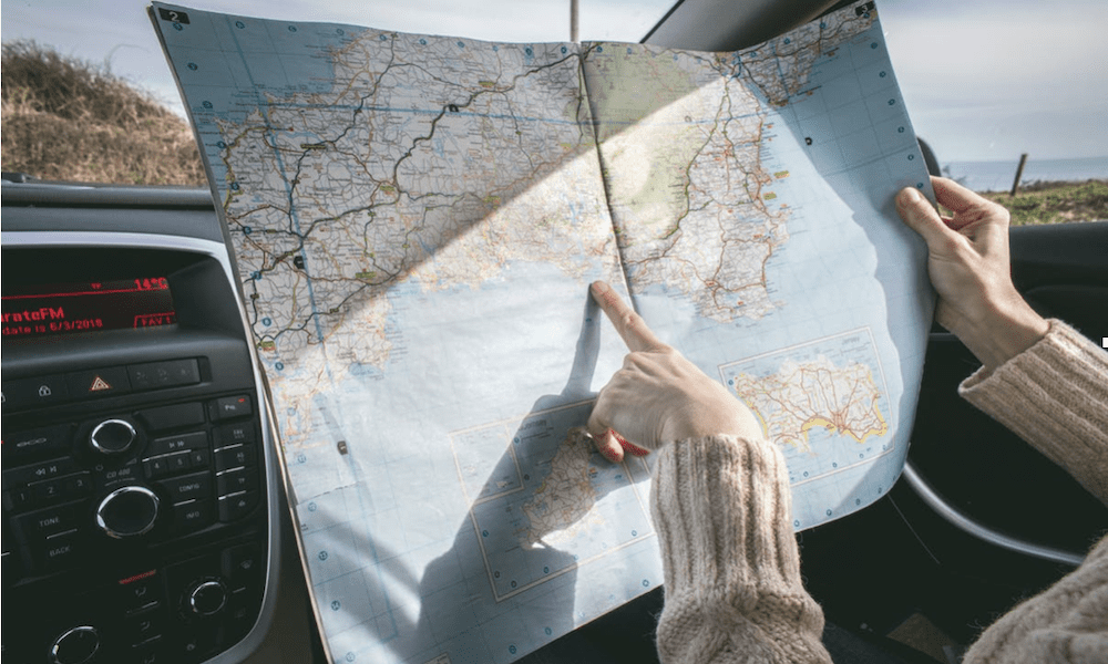 Automobile Insurance - a person on a road trip, reading a map