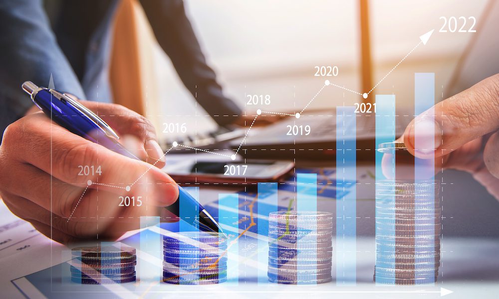 Insurance Trend Check-In - What Are We Learning in 2023? - To men standing at a desk counting money with a graph imposed over the photo