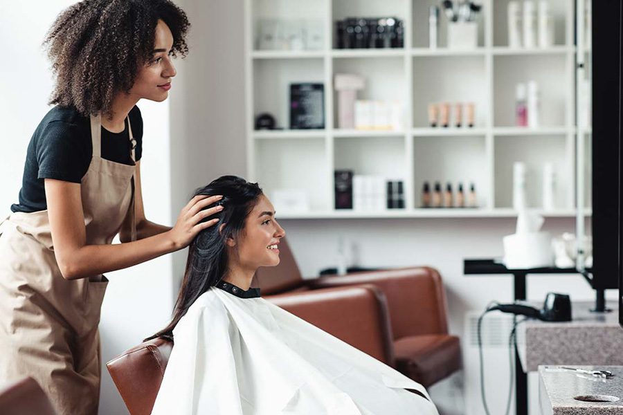 Beauty Salon Insurance - Young Woman Looking for Changes and Getting Hairstyle Advice from Stylist at a Beauty Salon
