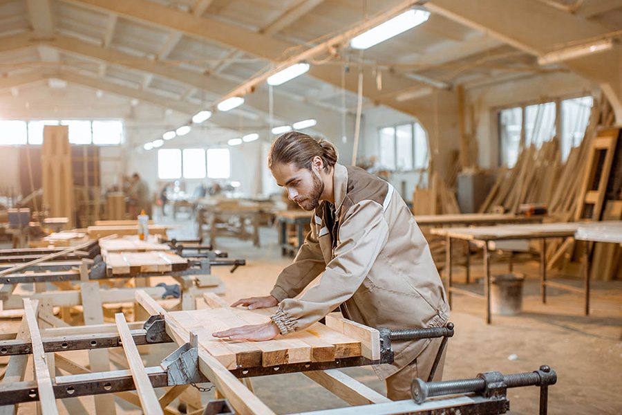 Carpenter Insurance - Man Working In His Woodshop on a Large Wood Project